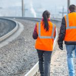 Two Rail Safety Workers walking down railway tracks.